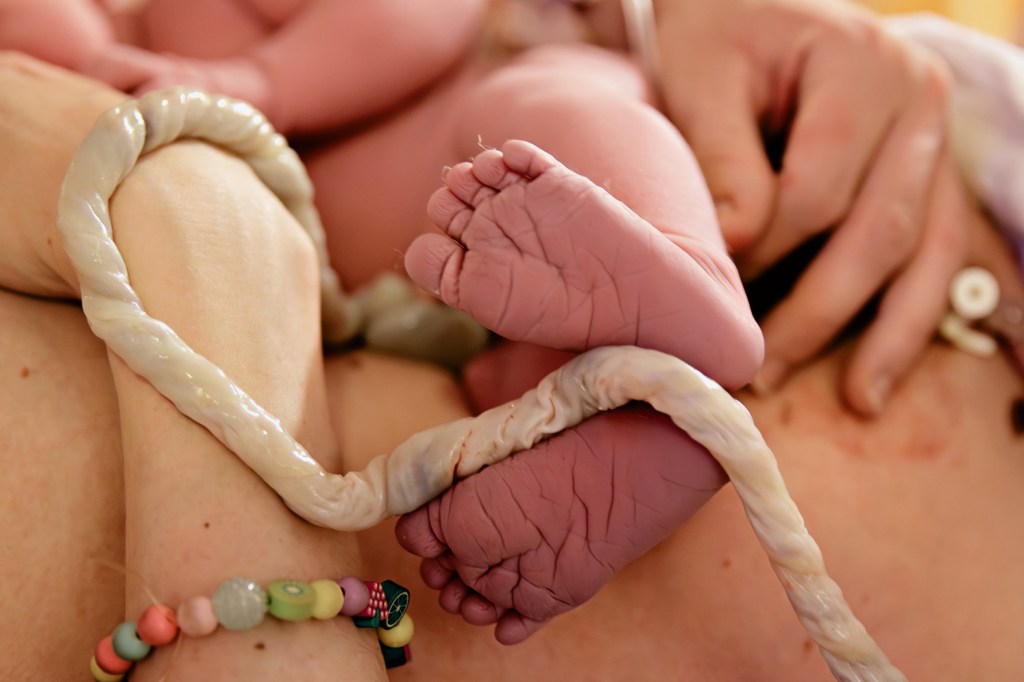 Pasgeboren voetjes met de navelstreng